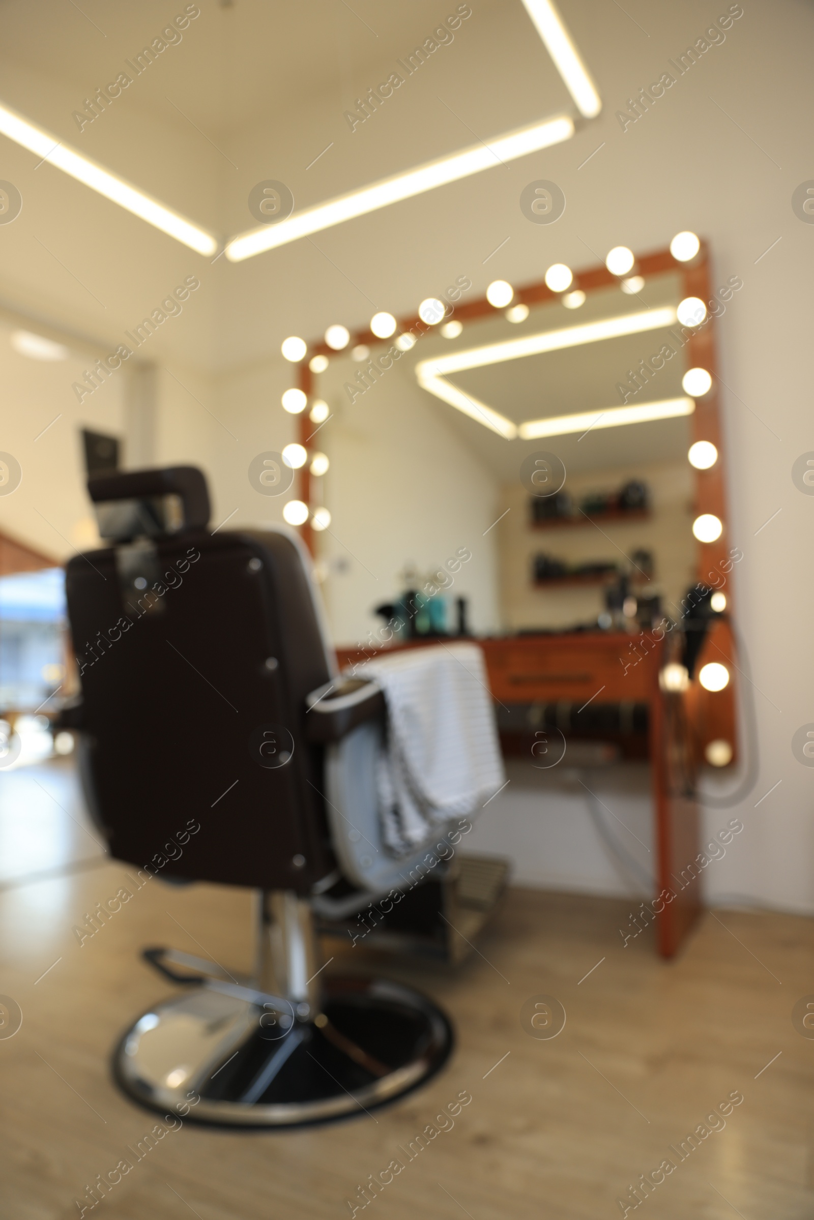 Photo of Blurred view of stylish barbershop interior with hairdresser workplace