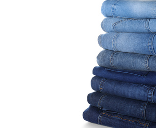 Photo of Stack of different jeans isolated on white