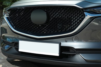 Car with vehicle registration plate outdoors, closeup