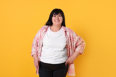 Photo of Beautiful overweight mature woman with charming smile on yellow background