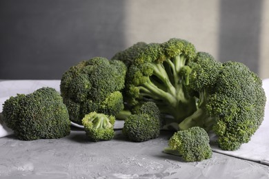 Fresh raw broccoli on grey textured table, closeup