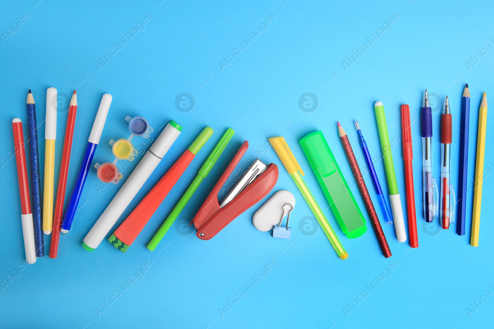 Photo of Flat lay composition with different school stationery on light blue background. Back to school