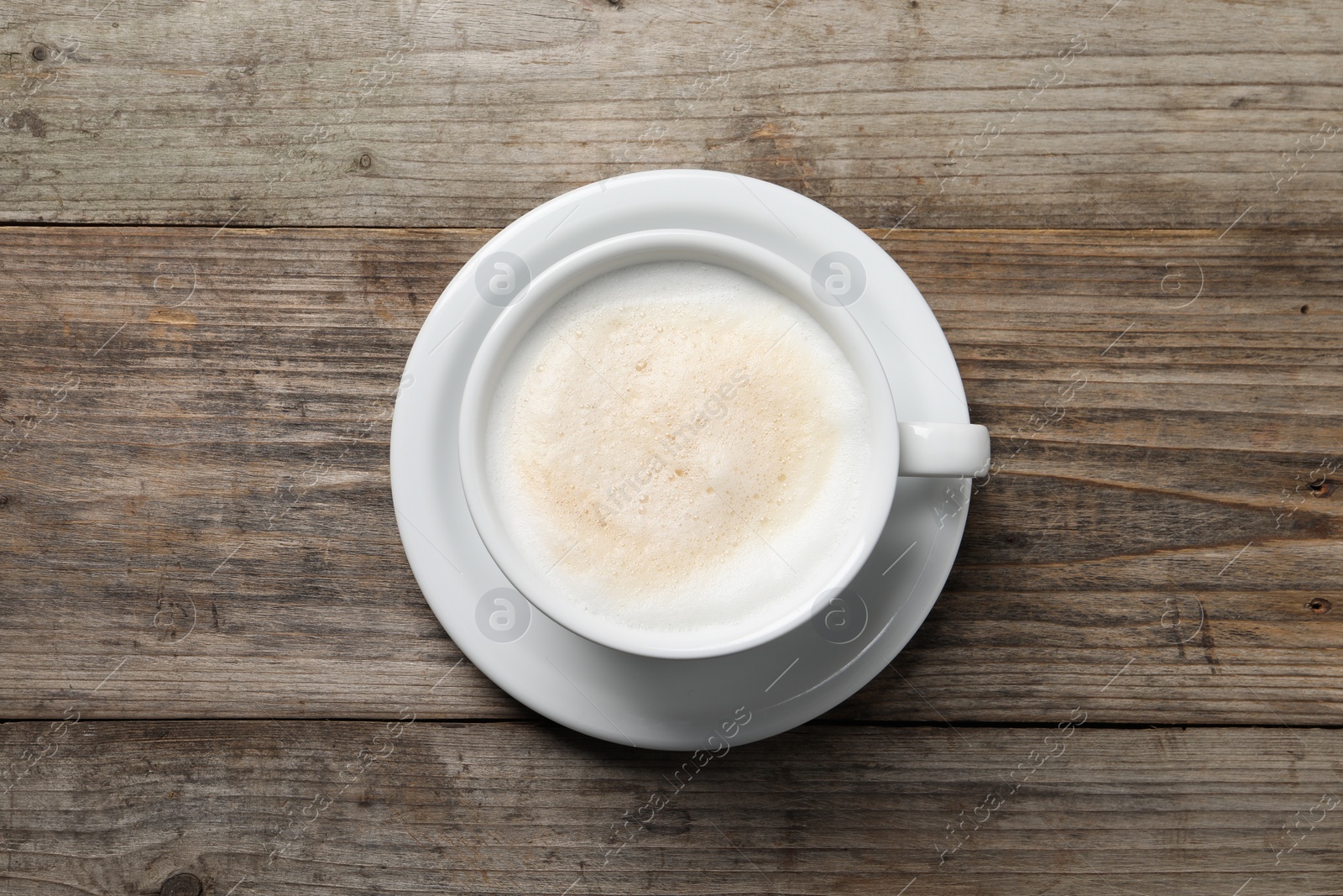 Photo of Aromatic coffee in cup on wooden table, top view