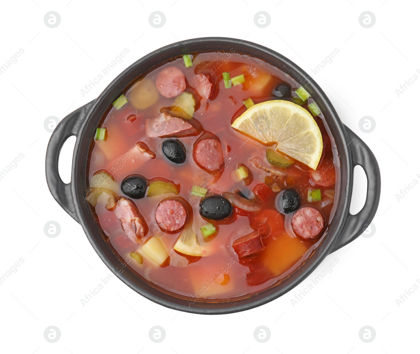 Photo of Meat solyanka soup with thin dry smoked sausages in bowl isolated on white, top view