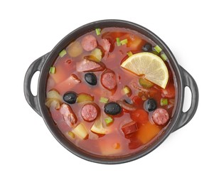 Photo of Meat solyanka soup with thin dry smoked sausages in bowl isolated on white, top view