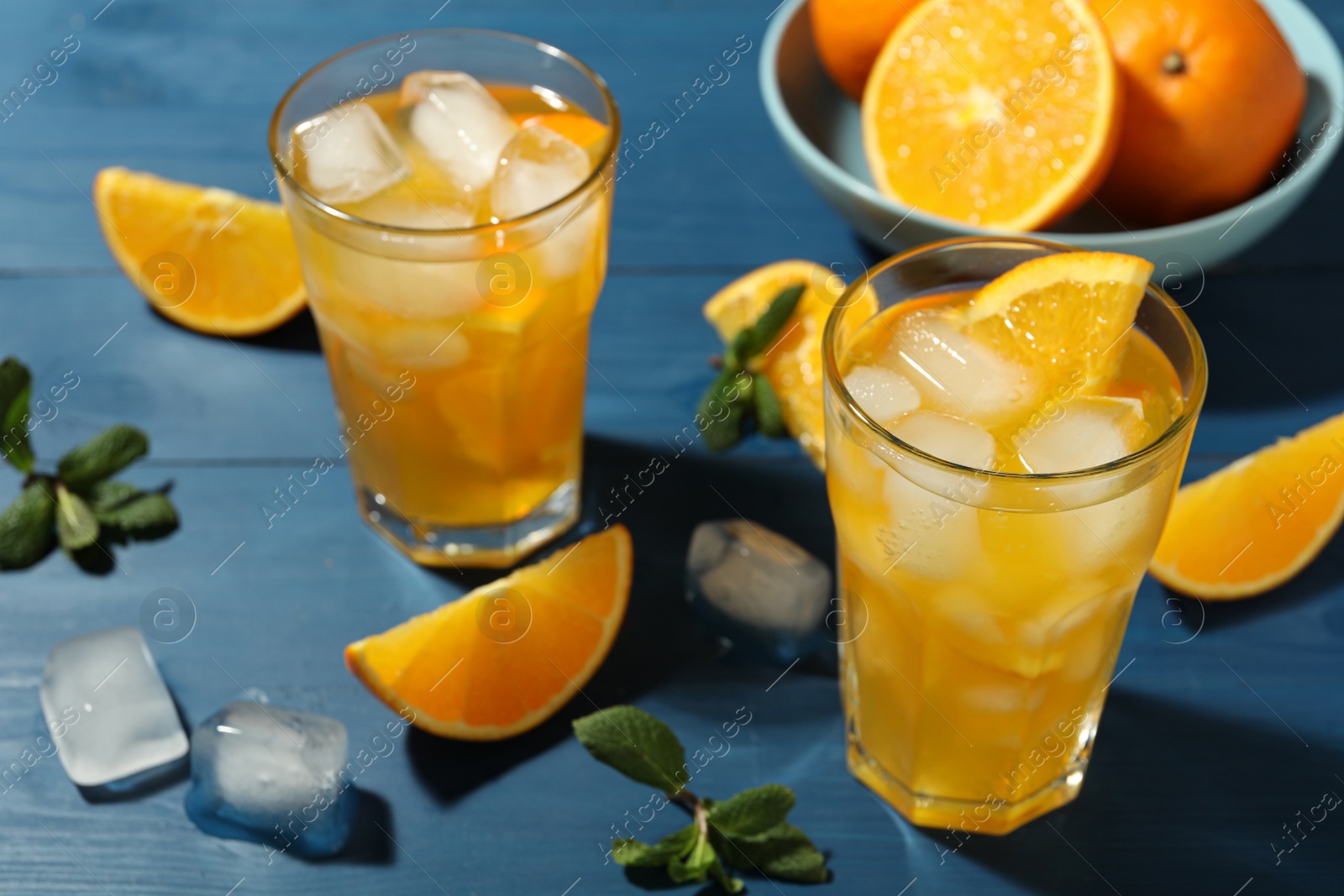 Photo of Delicious orange soda water on blue wooden table