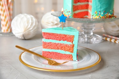 Photo of Slice of fresh delicious birthday cake with candle on table