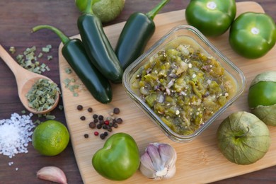 Photo of Tasty salsa sauce and ingredients on wooden table, flat lay