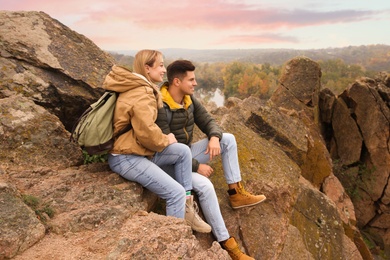 Couple of hikers with travel backpacks enjoying beautiful view of nature