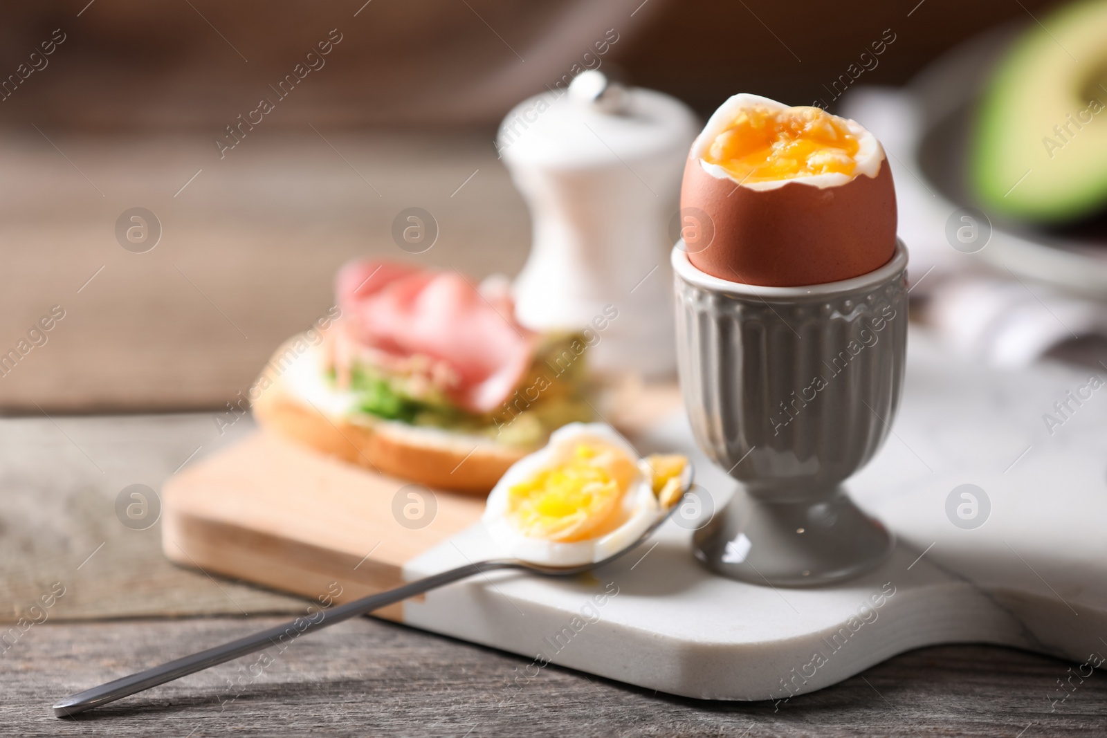 Photo of Soft boiled chicken egg served on wooden table, space for text