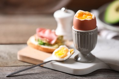 Photo of Soft boiled chicken egg served on wooden table, space for text