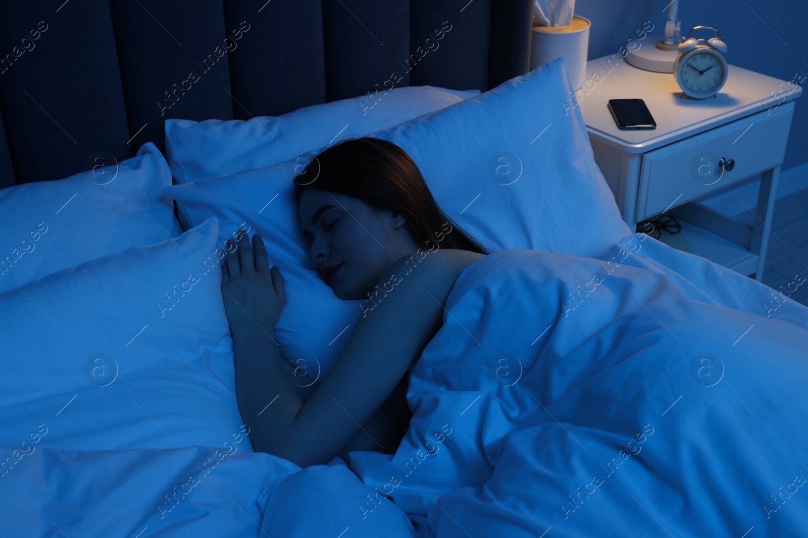 Photo of Beautiful young woman sleeping in bed at night