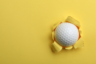 Photo of Torn color paper with golf ball, space for text. Sport equipment