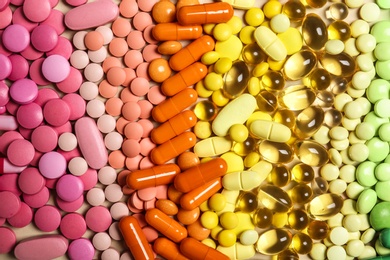Different colorful pills as background, top view