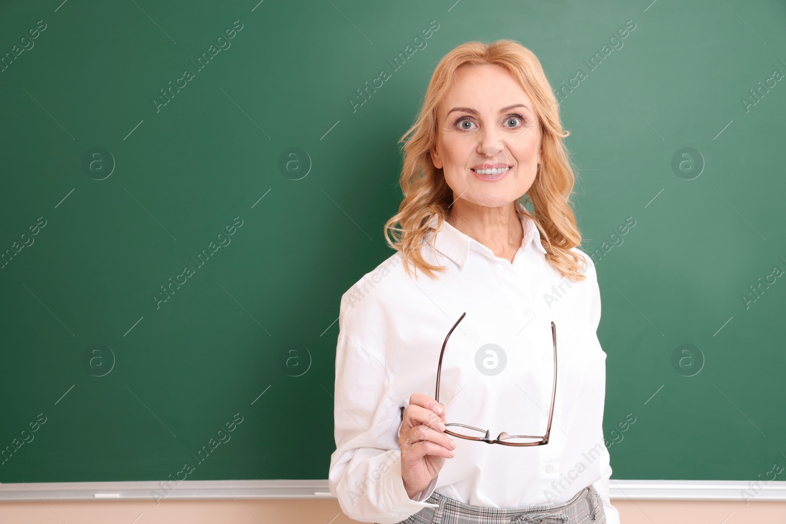 Photo of Happy professor with glasses near green board, space for text