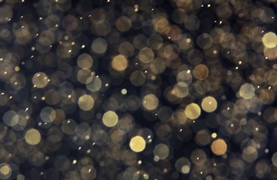 Golden glitter with bokeh effect on dark background