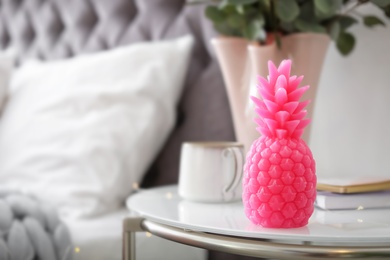 Pineapple shaped candle on bedside table in room