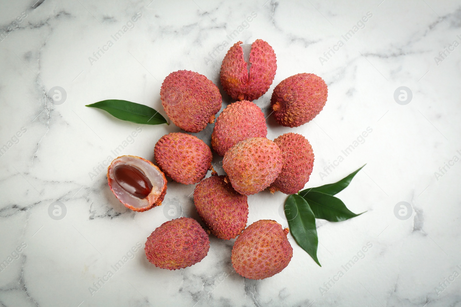 Photo of Fresh ripe lychee fruits on white marble table, flat lay