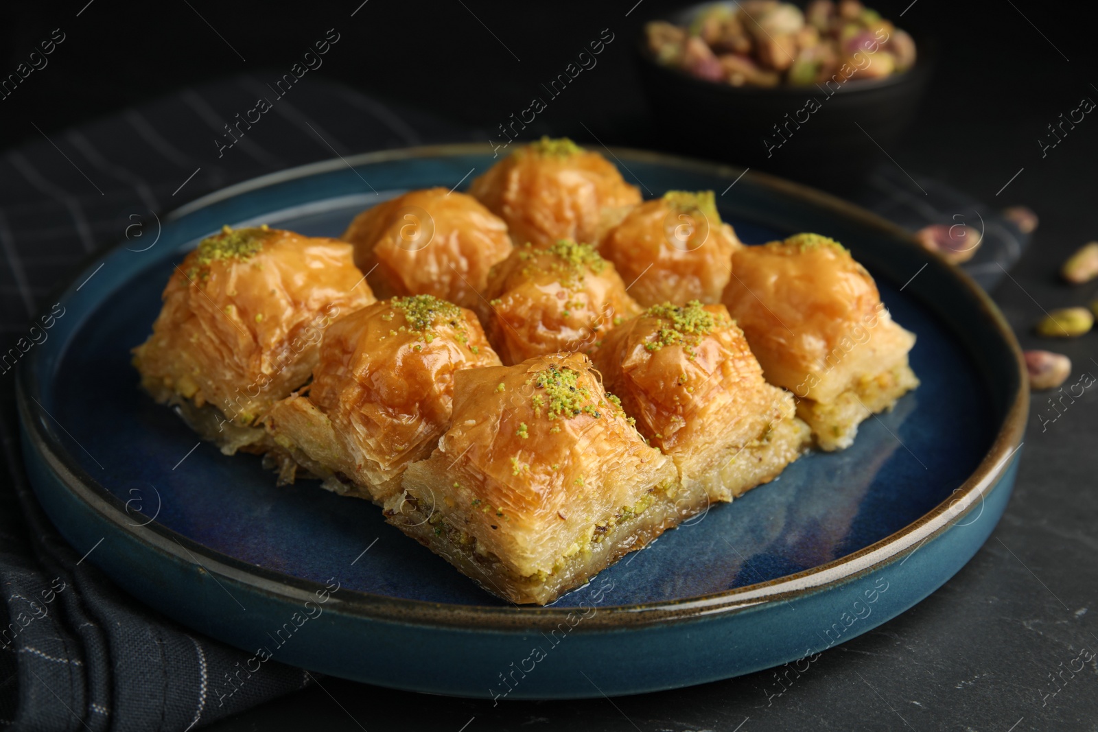 Photo of Delicious sweet baklava on black table, closeup