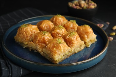 Photo of Delicious sweet baklava on black table, closeup