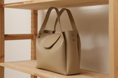 Photo of Stylish woman's bag on shelf in boutique