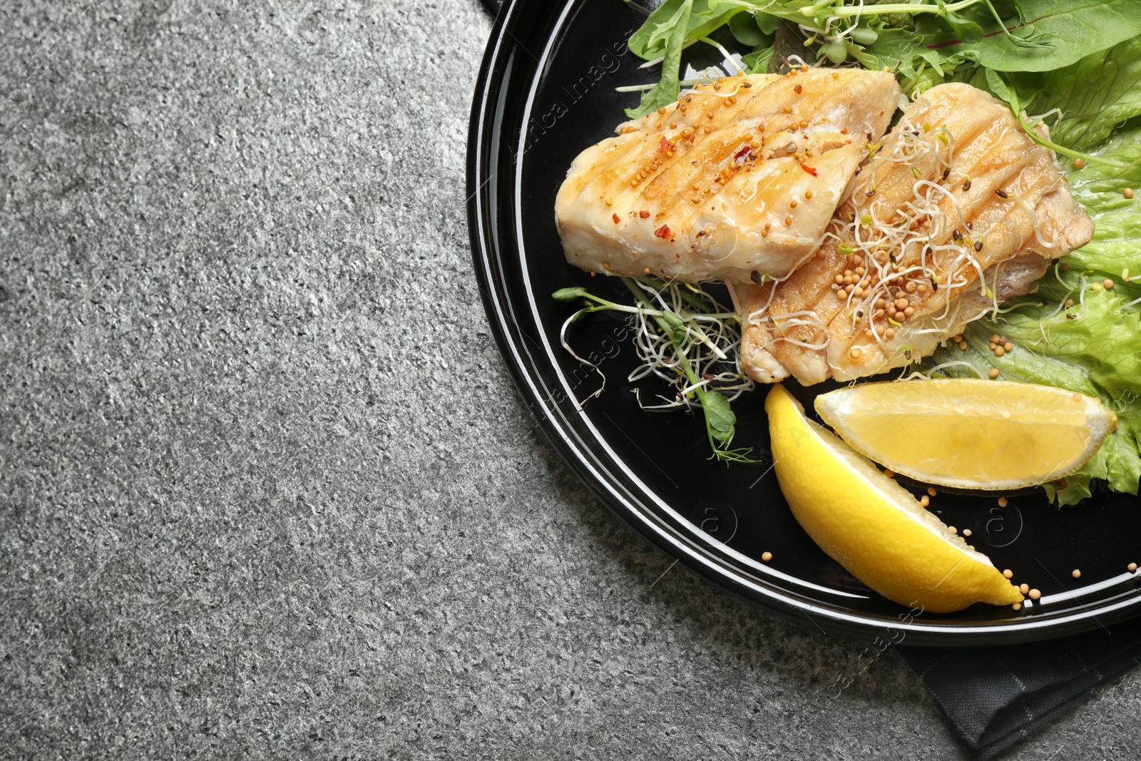 Photo of Tasty grilled fish on grey table, top view