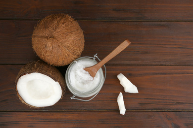 Photo of Flat lay composition with organic coconut oil on wooden table. Healthy cooking