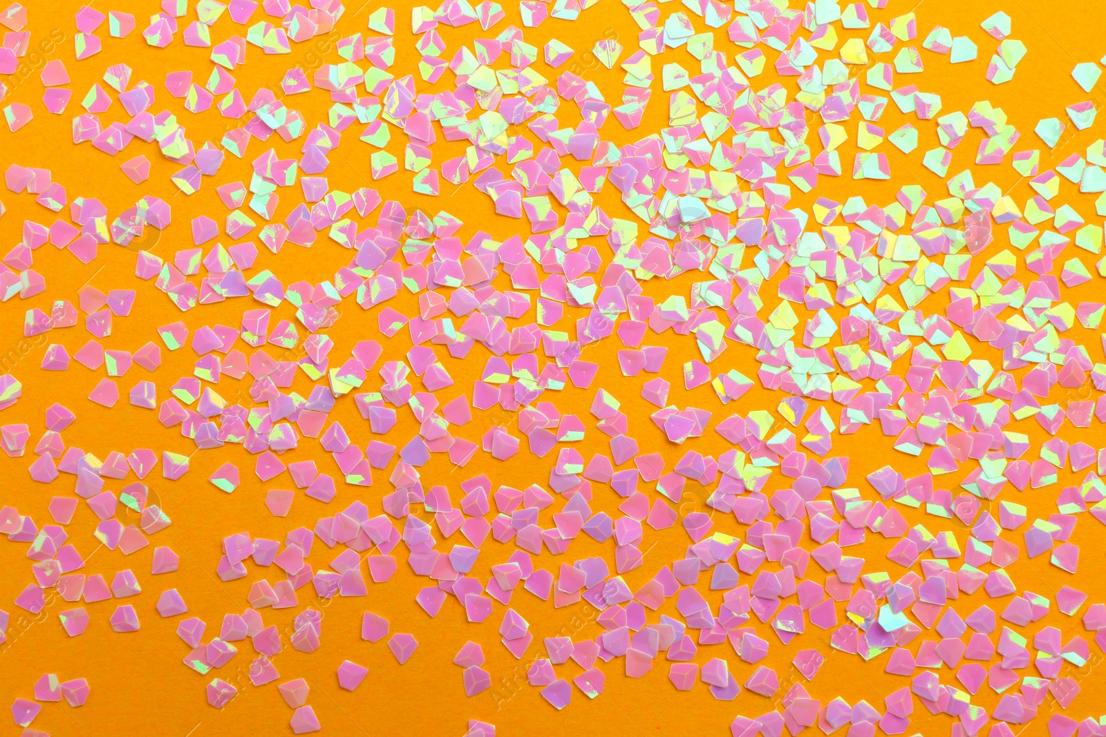 Photo of Shiny bright pink glitter on orange background, flat lay