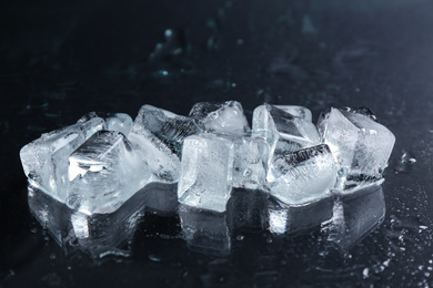 Ice cubes on wet black surface, closeup