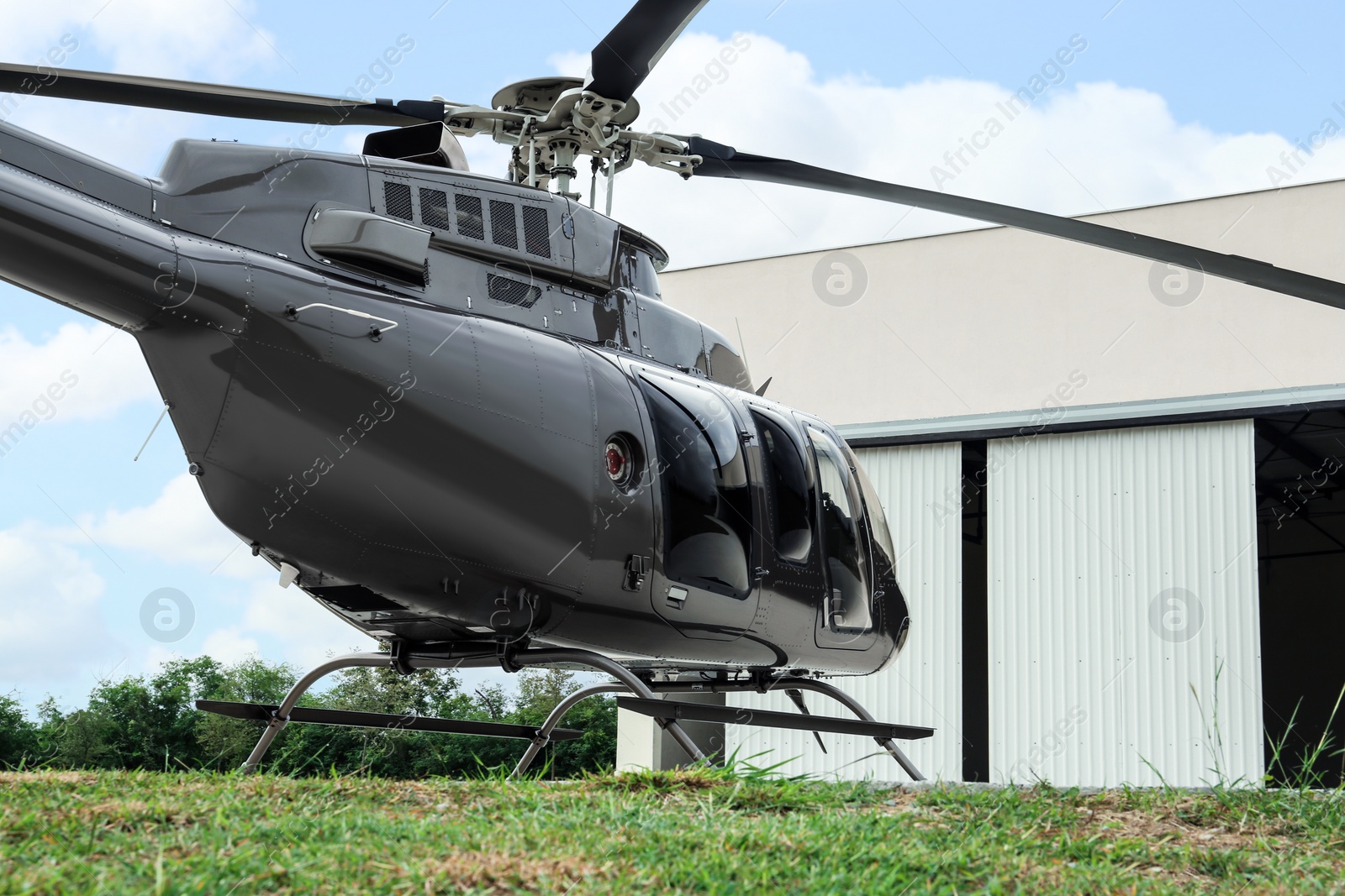 Photo of Beautiful helicopter on helipad near white hangar