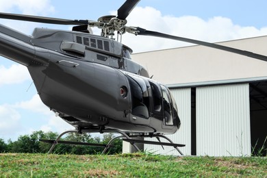 Beautiful helicopter on helipad near white hangar