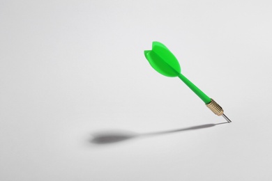 Photo of Green dart arrow for game on white background