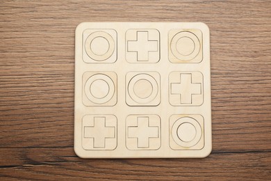 Photo of Tic tac toe set on wooden table, top view