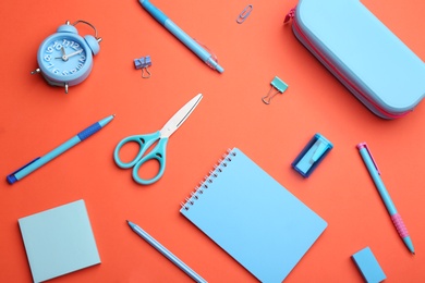 Photo of Different bright school stationery on coral background, flat lay