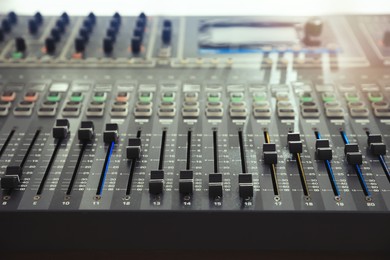 Photo of Professional mixing console on table in modern radio studio, closeup
