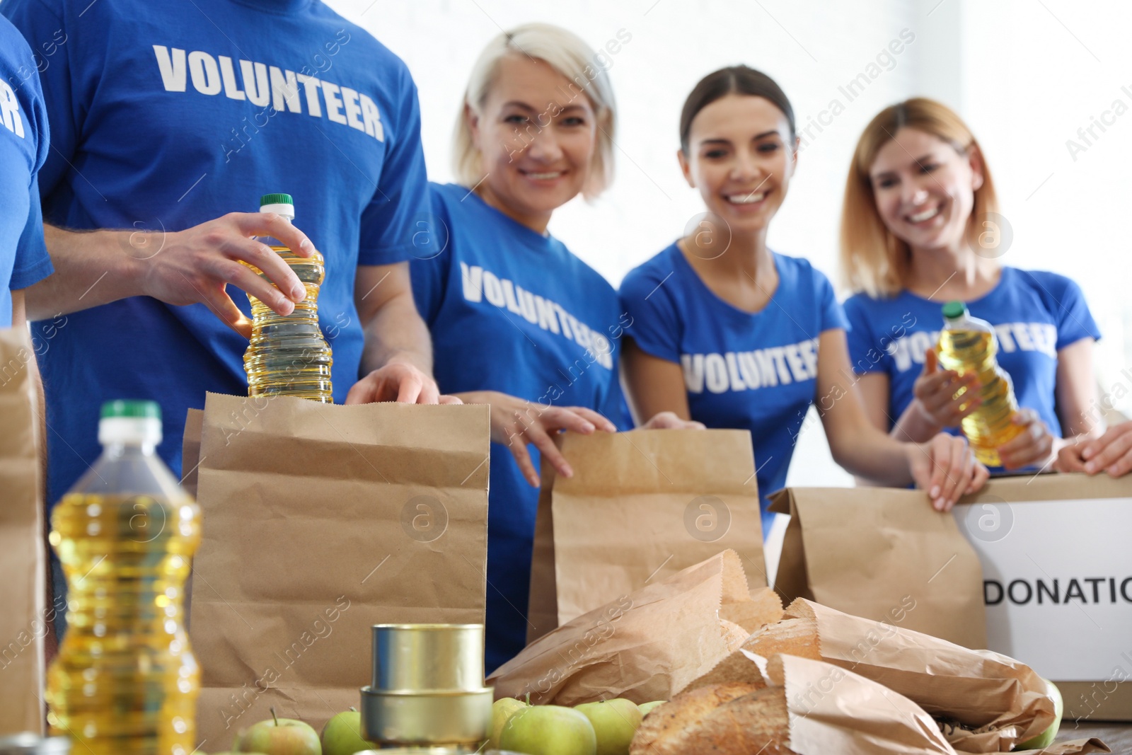 Photo of Team of volunteers collecting food donations at table, closeup