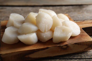 Photo of Fresh raw scallops on wooden table, closeup
