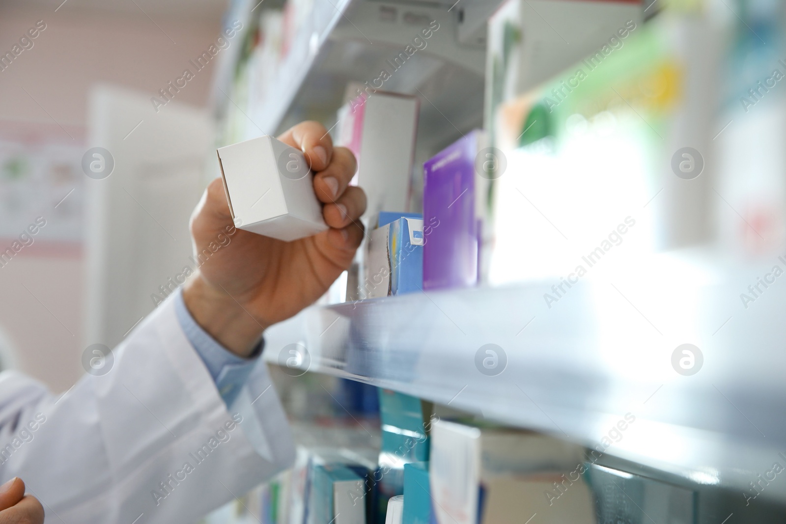 Photo of Professional pharmacist with medicine in modern drugstore, closeup