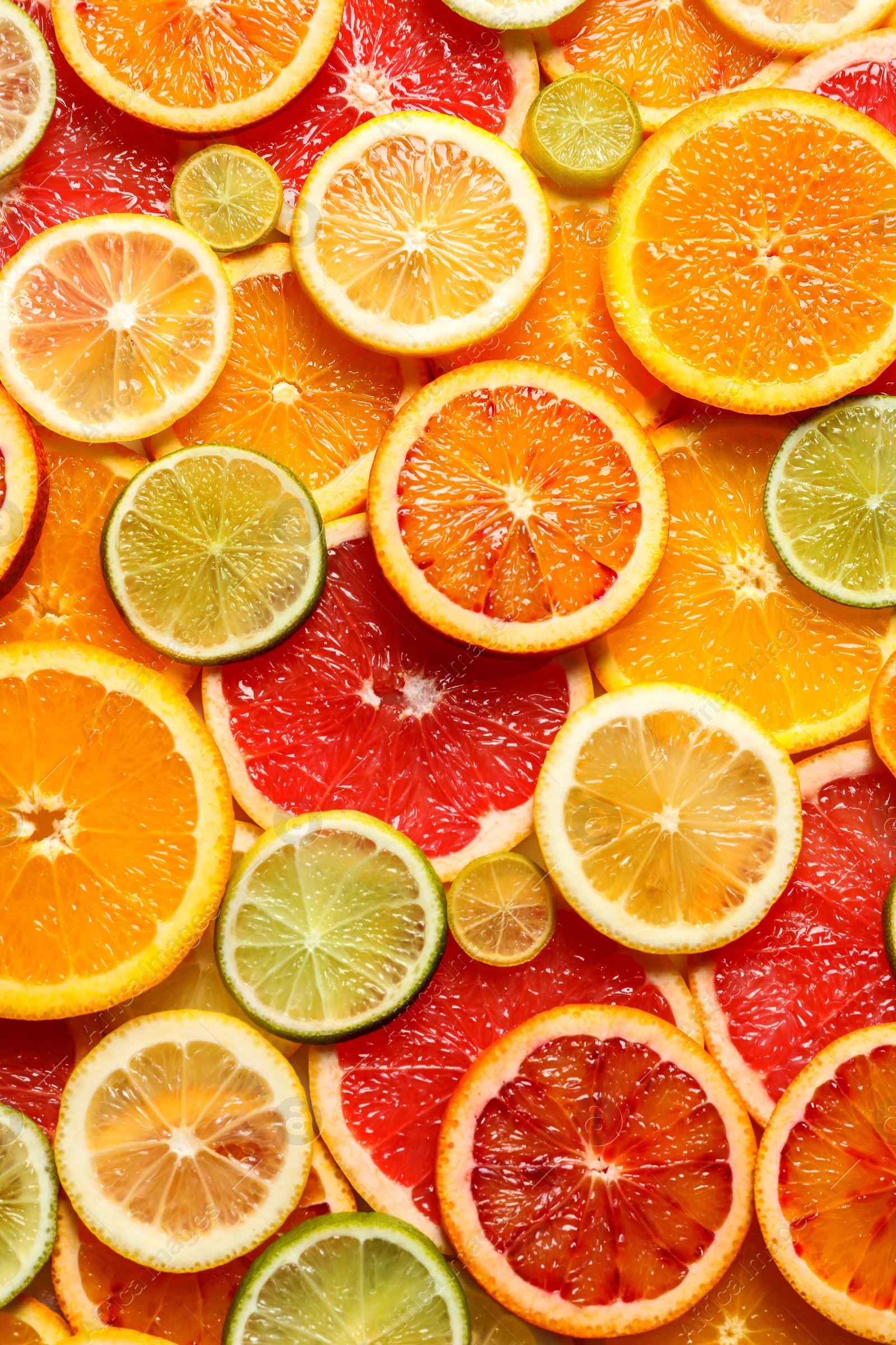 Photo of Slices of fresh citrus fruits as background, top view