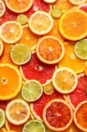 Photo of Slices of fresh citrus fruits as background, top view