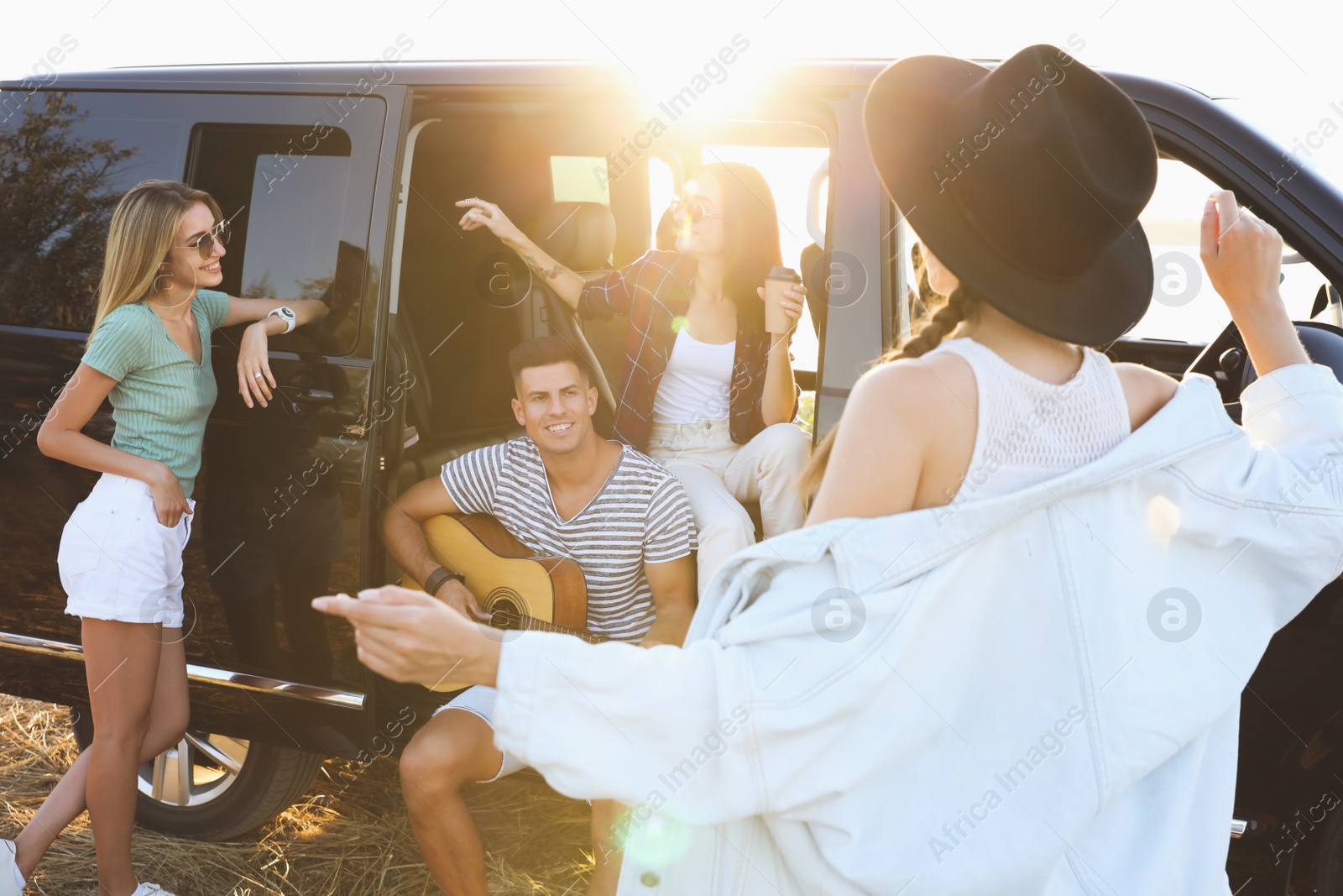 Photo of Happy friends having fun near car outdoors. Summer trip