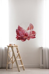 Photo of Unfinished flower painting on white wall in room. Interior design