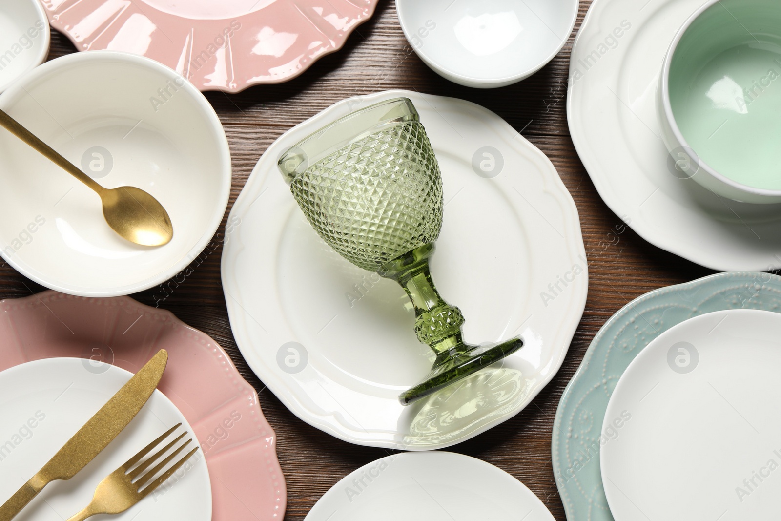 Photo of Beautiful ceramic dishware, glass and cutlery on wooden table, flat lay