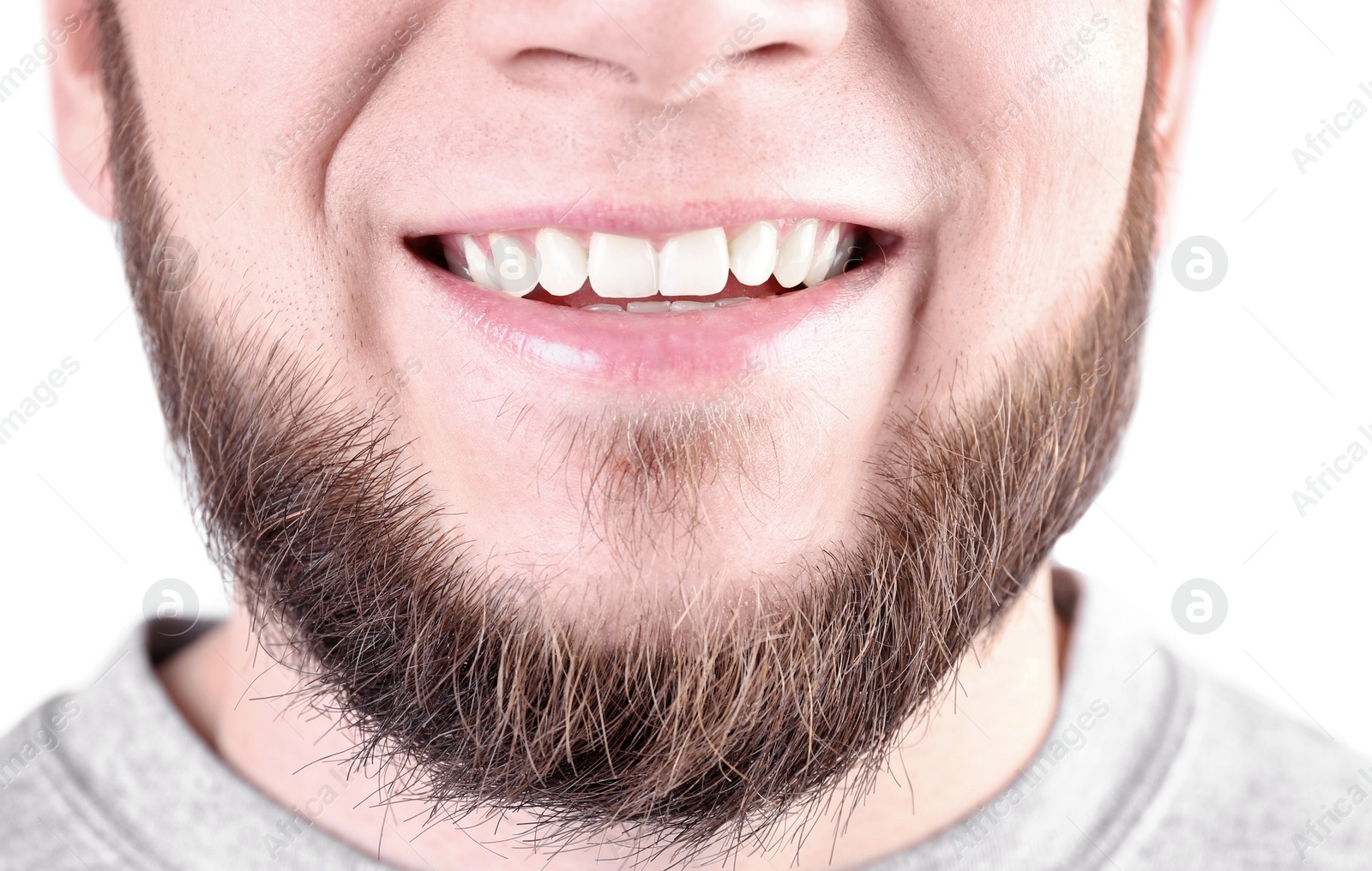 Photo of Young man with healthy teeth smiling on white background, closeup