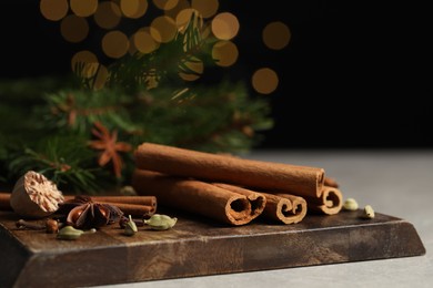 Board with different aromatic spices on table, closeup