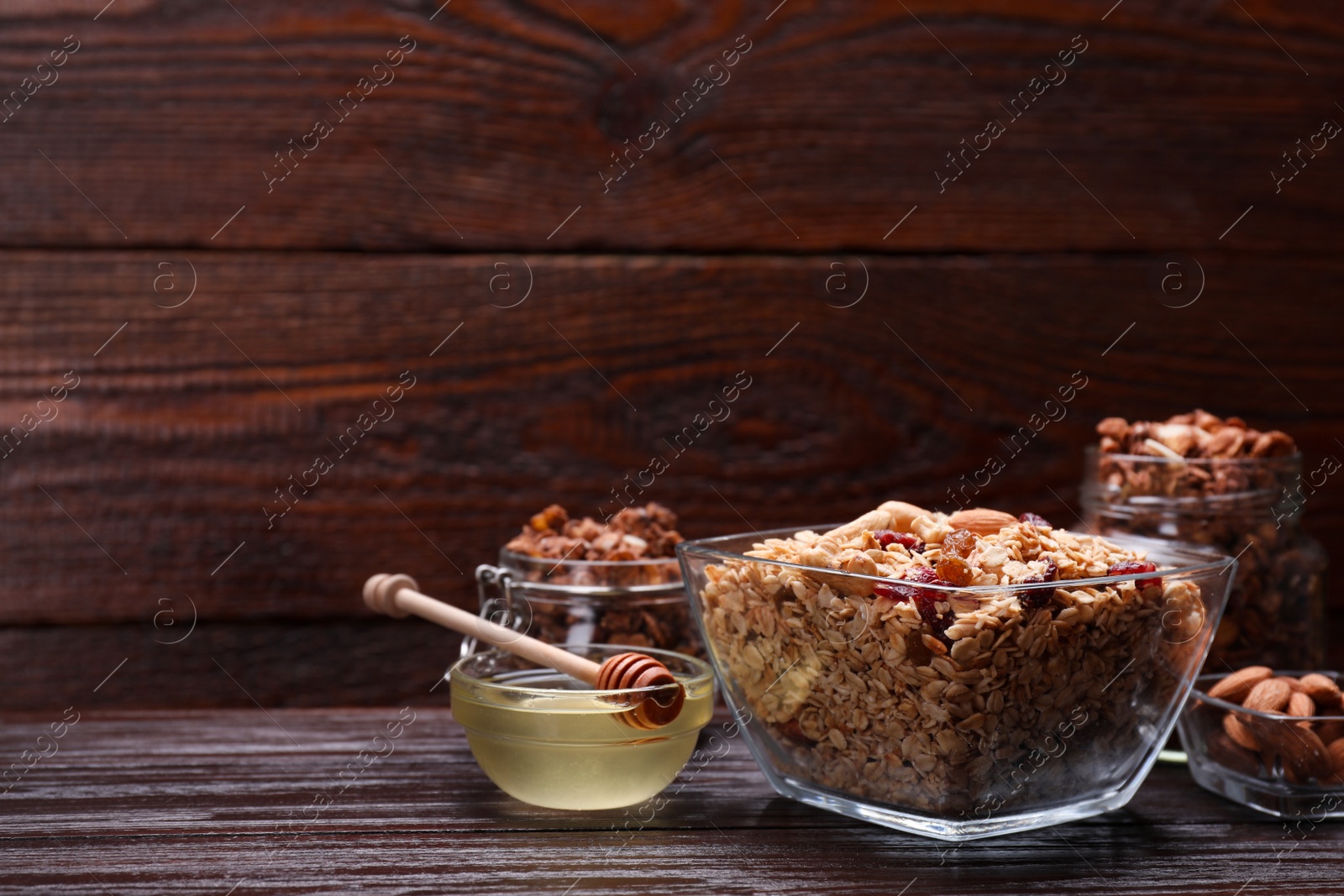 Photo of Tasty granola with nuts and dry fruits on wooden table. Space for text