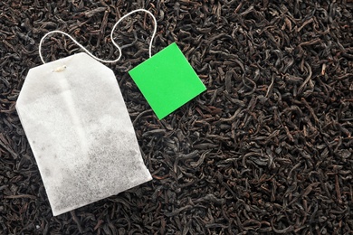 Tea bag on dry leaves, top view with space for text