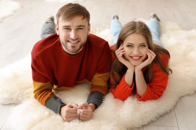 Photo of Happy young couple lying on floor at home. Christmas celebration