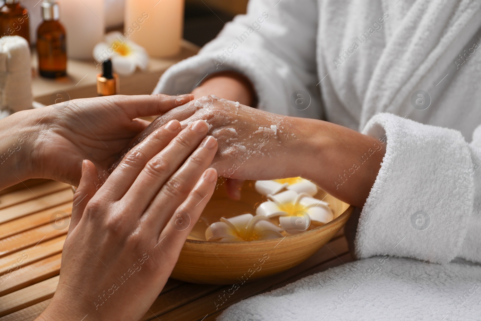 Photo of Woman receiving hand treatment at table in spa, closeup