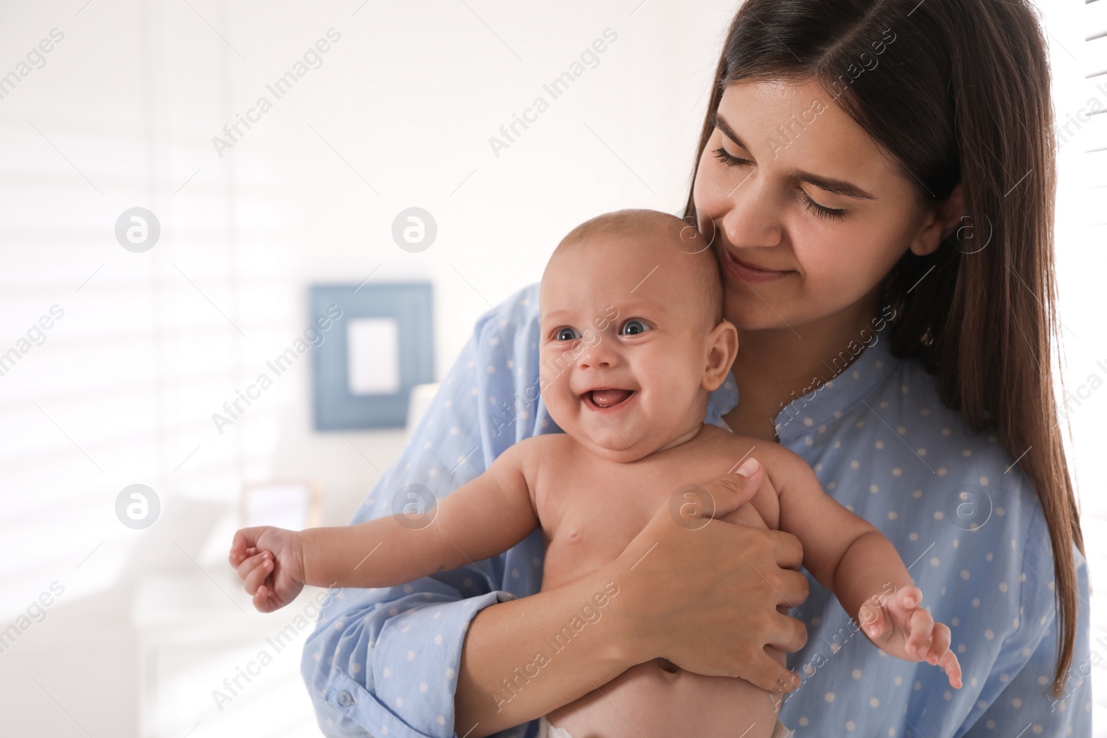 Photo of Happy young mother with her cute baby at home